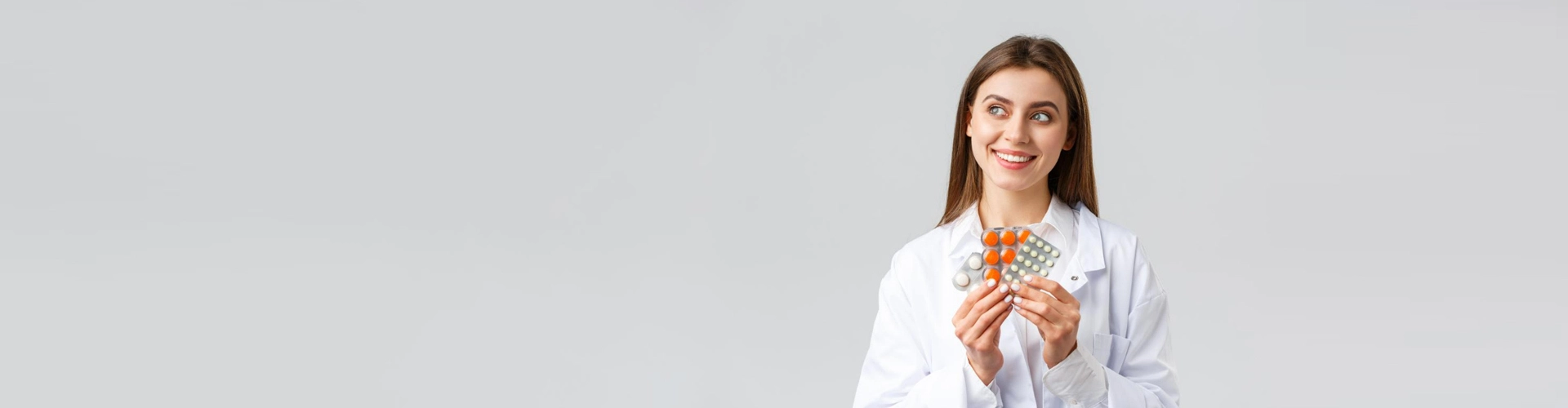 woman doctor holding pills and smiling