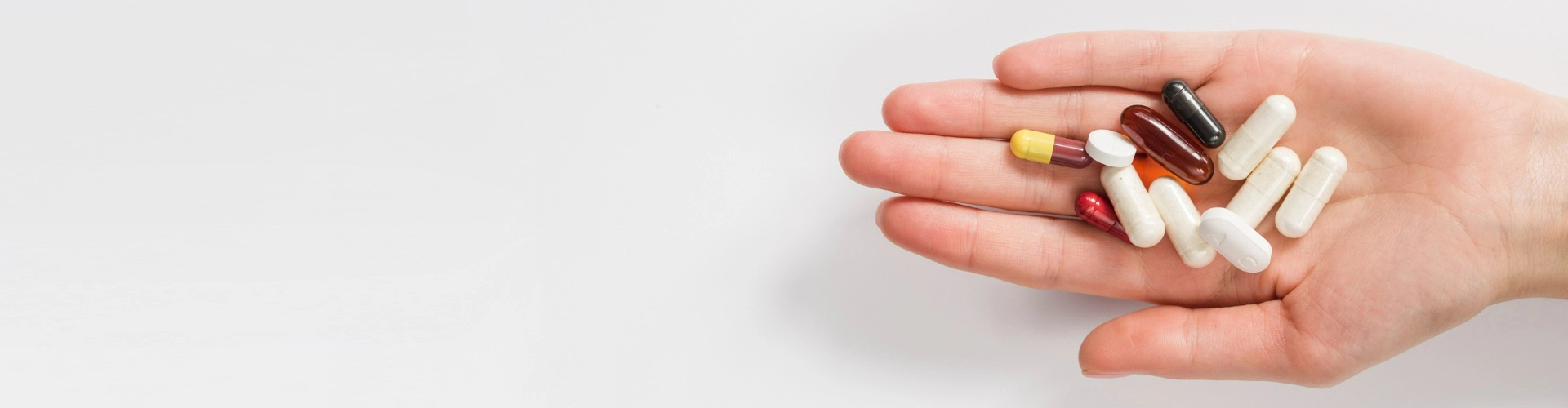 hand holding different colored pills