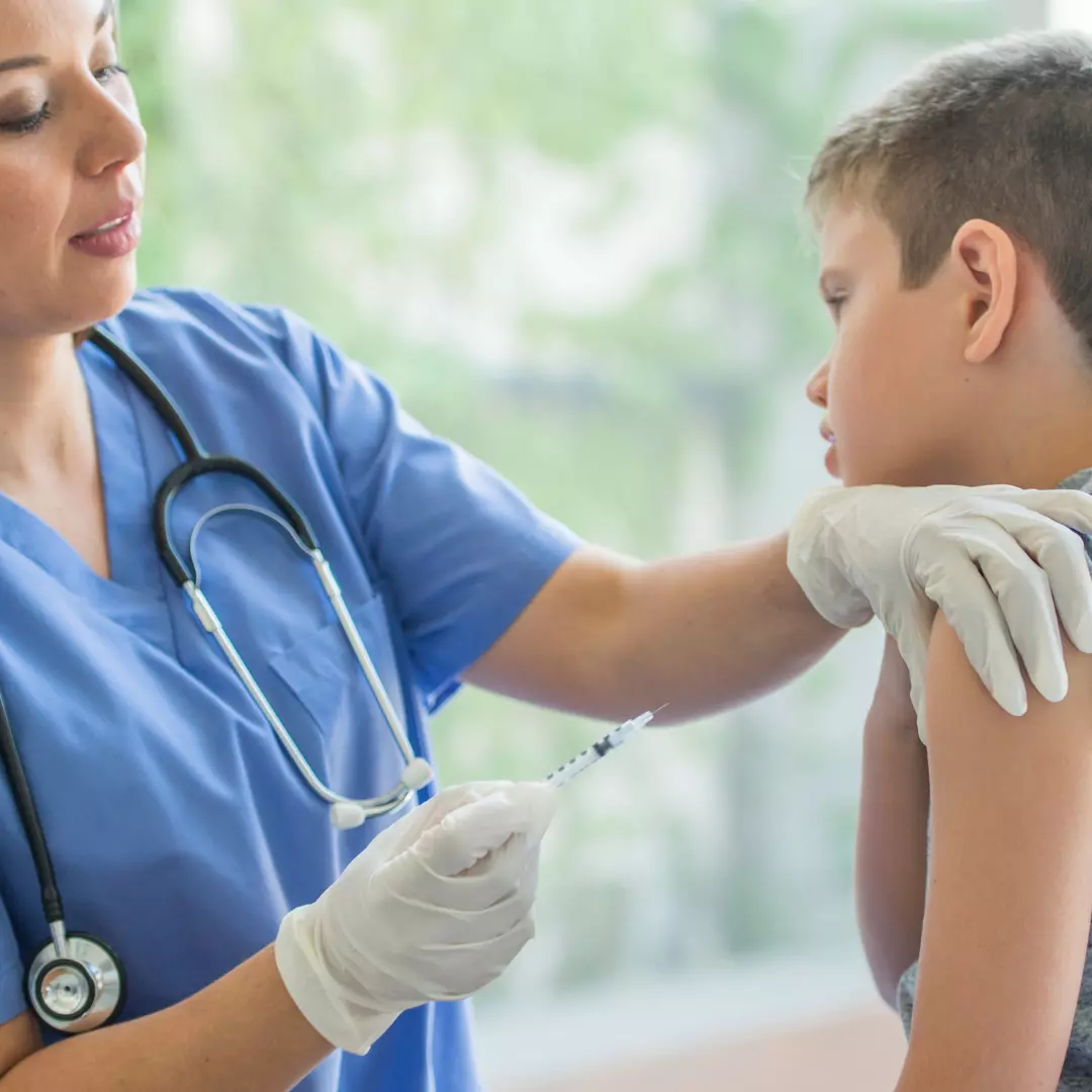 pharmacist giving boy a flu shot